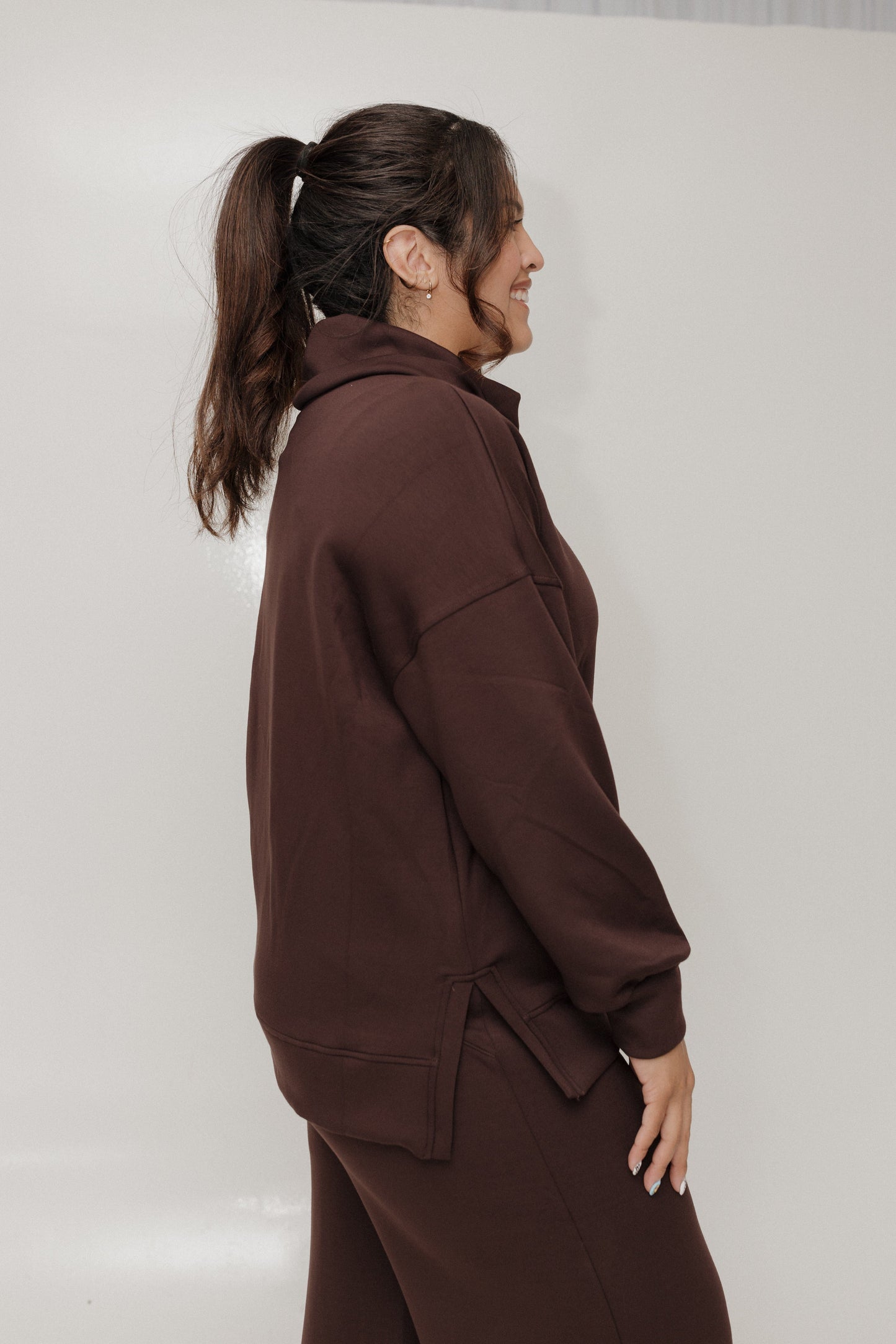 Person wearing a brown tracksuit against a plain background