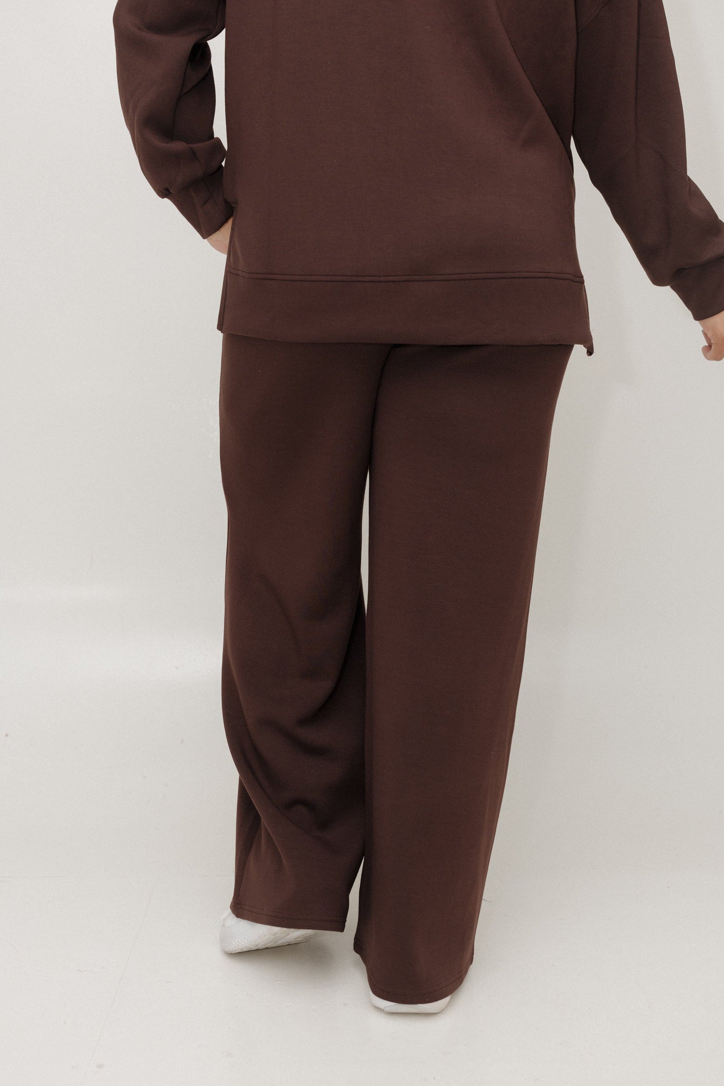 Brown tracksuit worn by a person on a white background