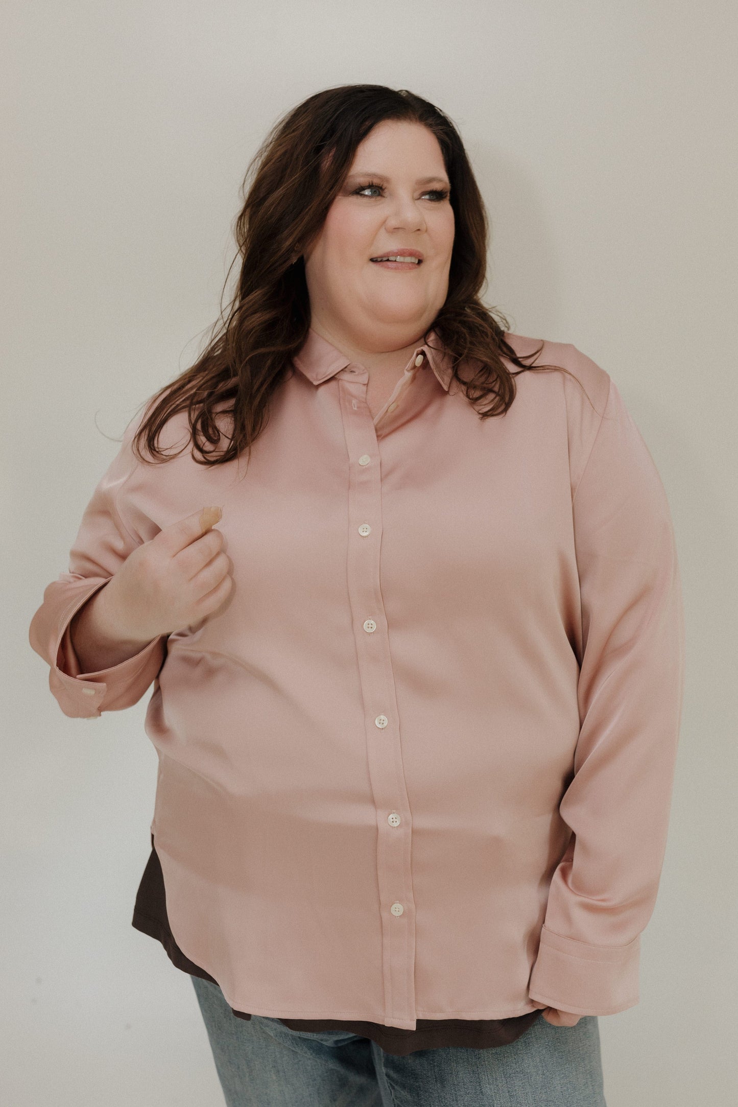 Woman wearing a light pink shirt against a plain background