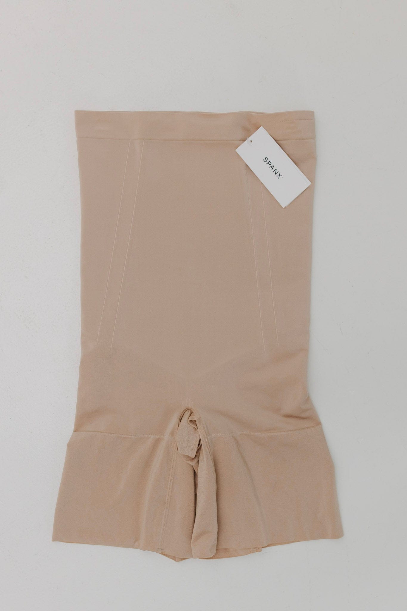 Beige fabric with a tie at the bottom on a white background