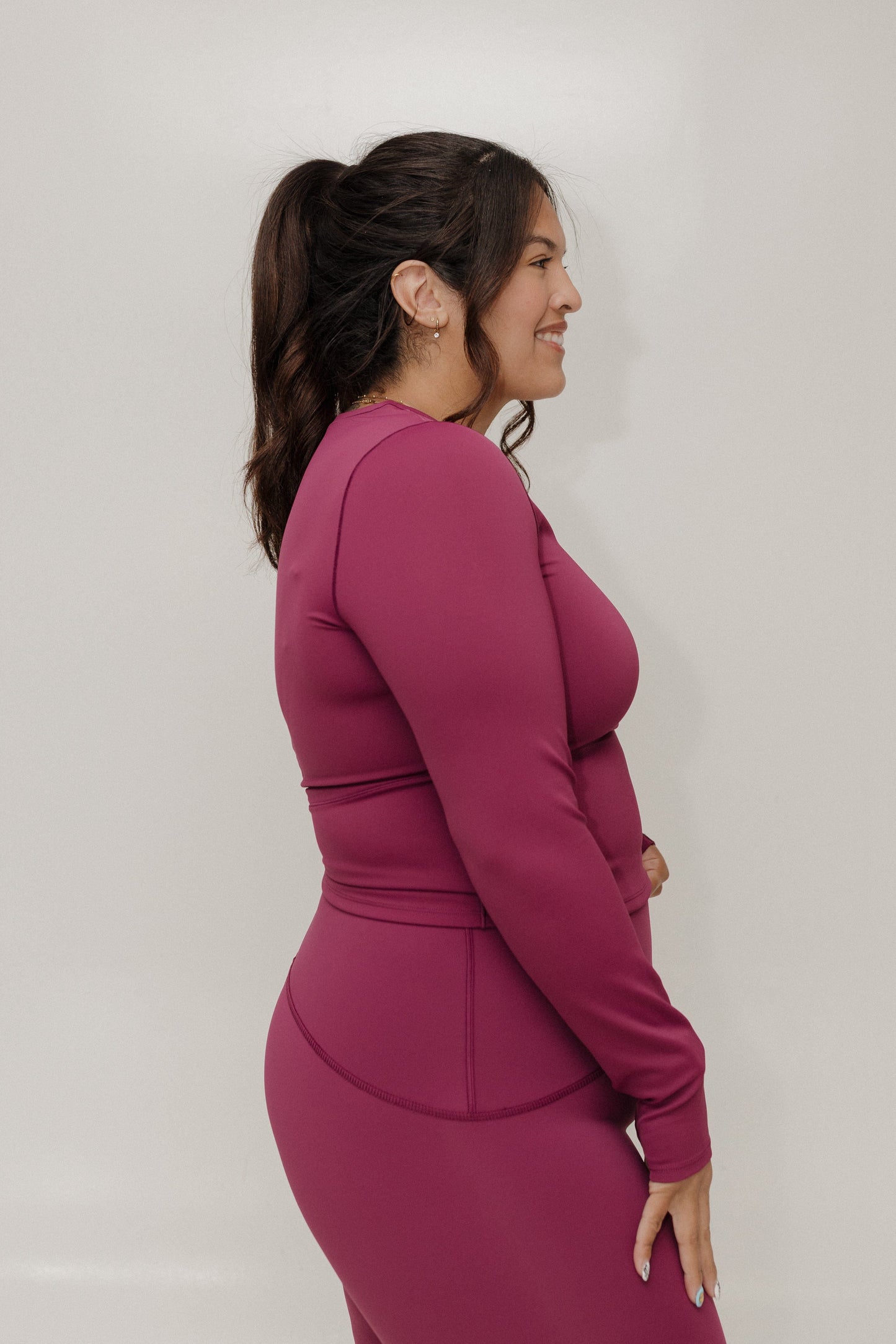 Woman wearing a magenta dress against a plain background