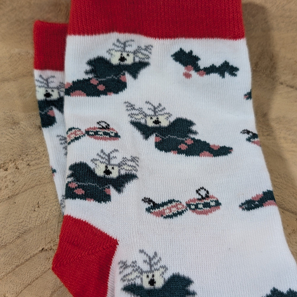 A pair of cozy white socks with red cuffs, adorned with black bats wearing sunglasses and red bows. Perfect for adding a playful touch to your holiday footwear collection.