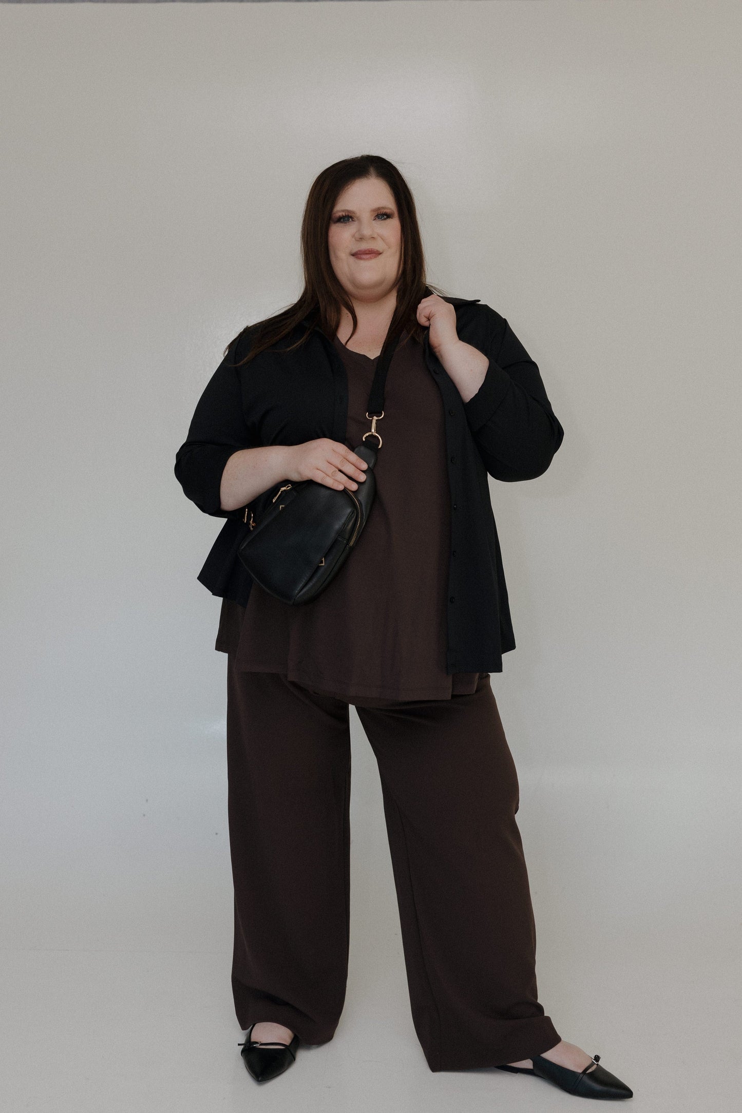 Woman wearing a black outfit with a plain background