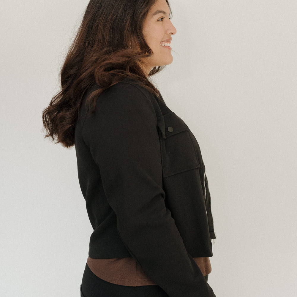 Woman wearing a black jacket against a white background