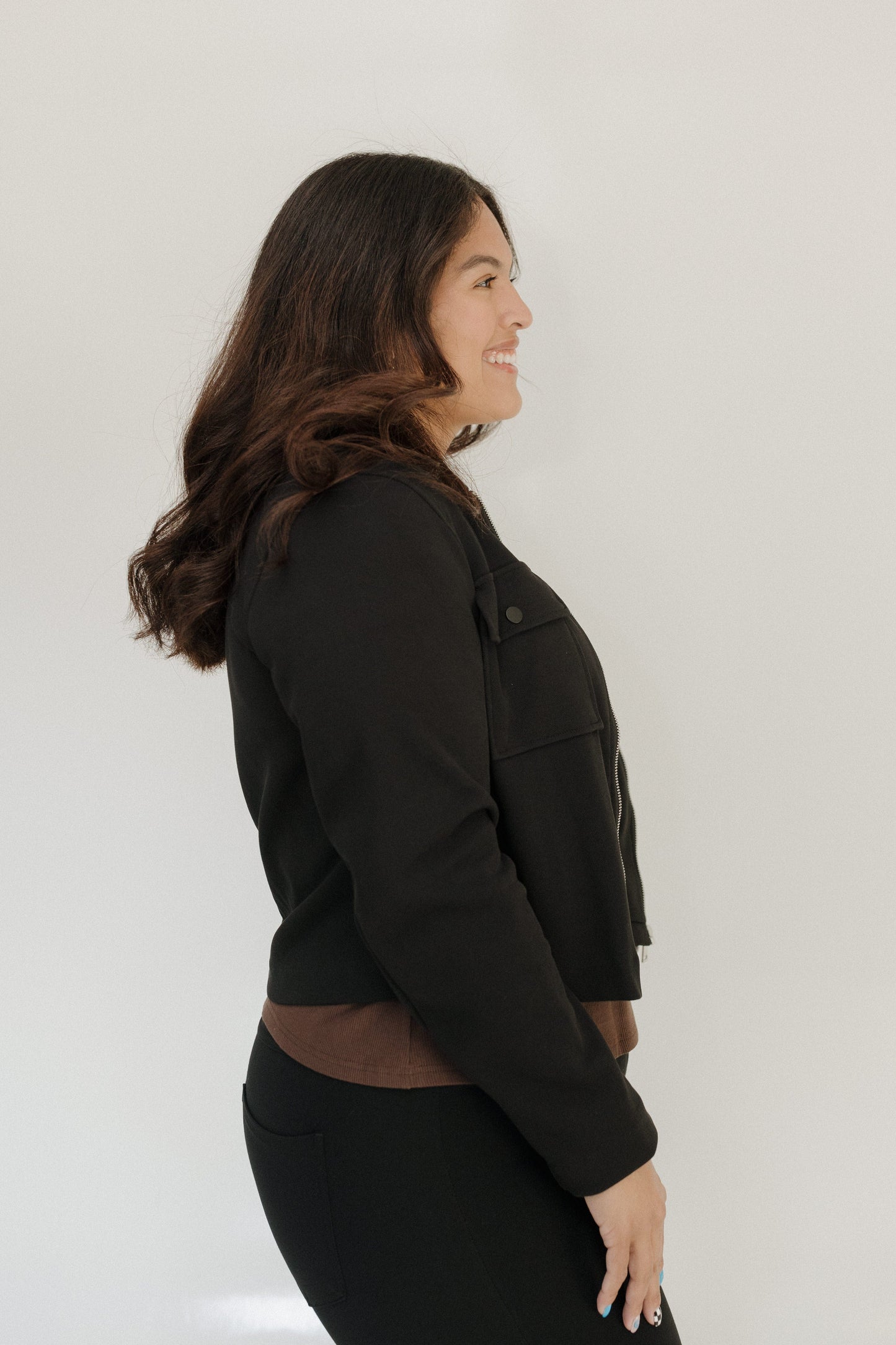 Woman wearing a black jacket against a white background