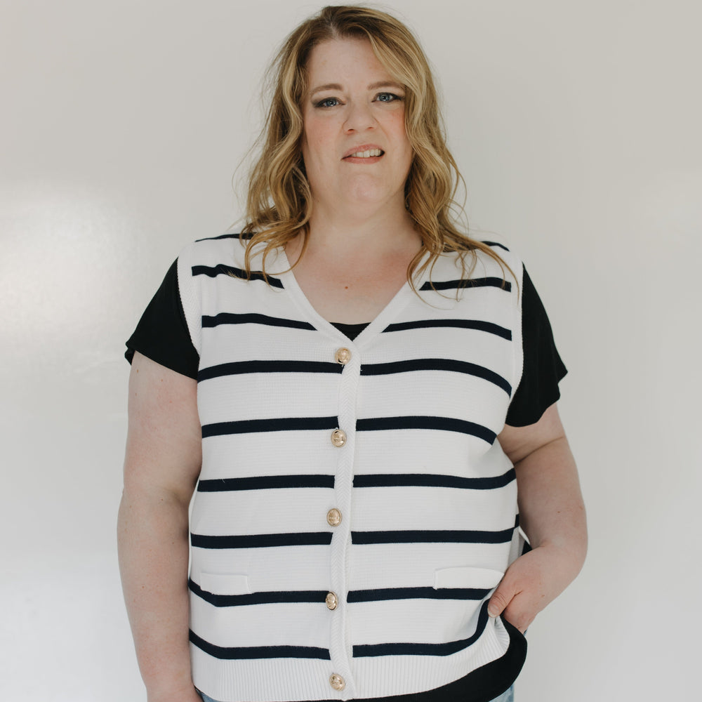 Person wearing a black and white striped shirt with a plain background