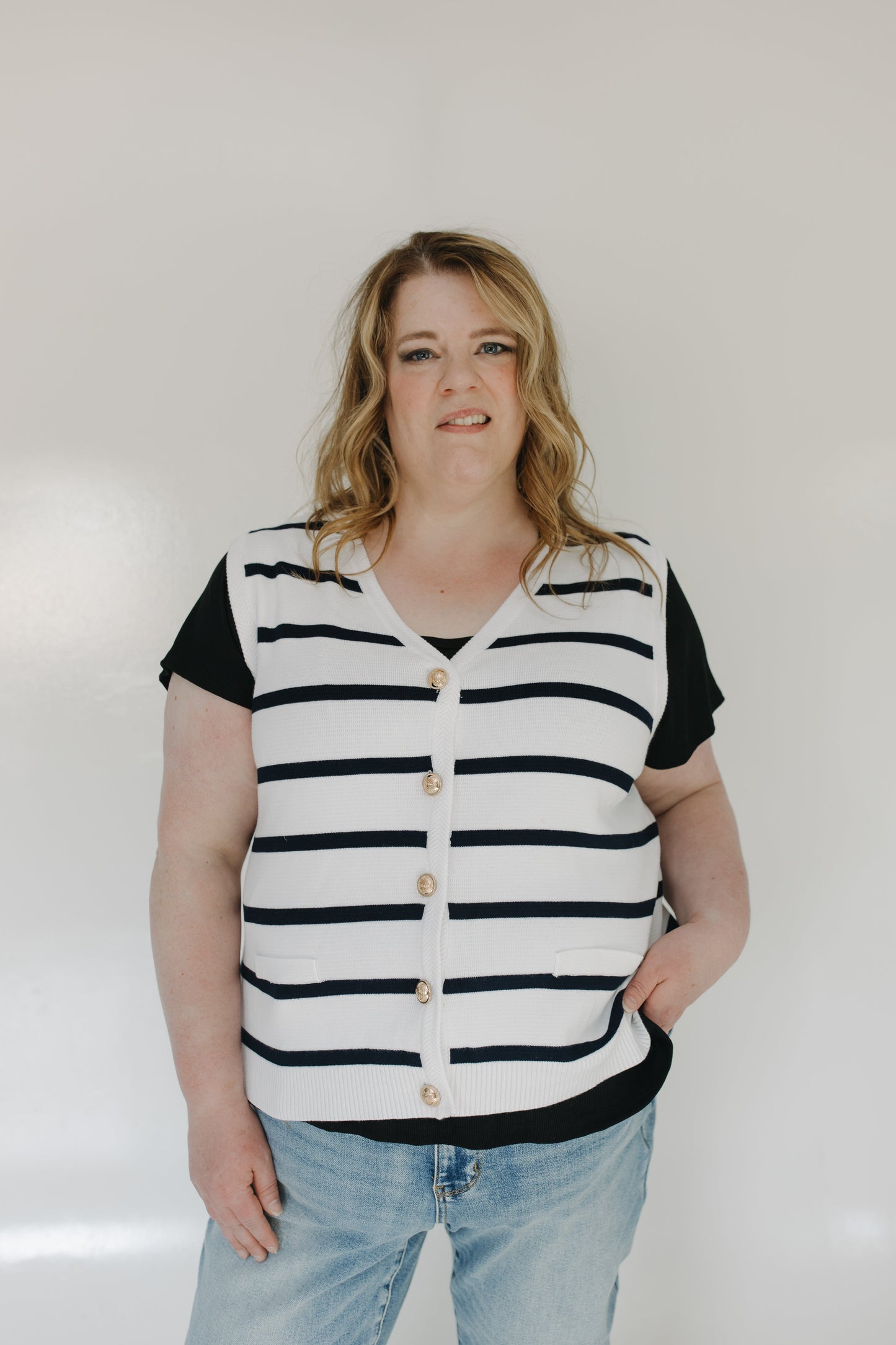Person wearing a black and white striped shirt with a plain background