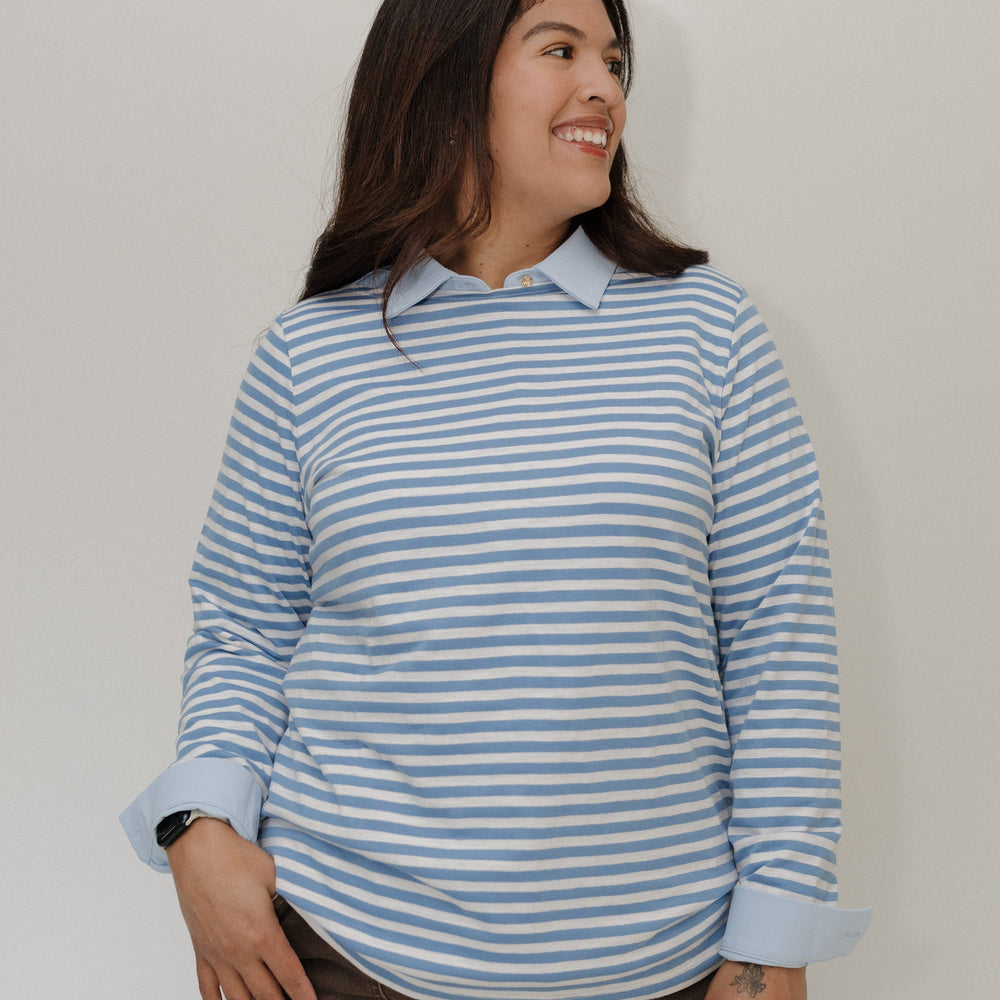 Woman wearing a blue and white striped shirt against a plain background