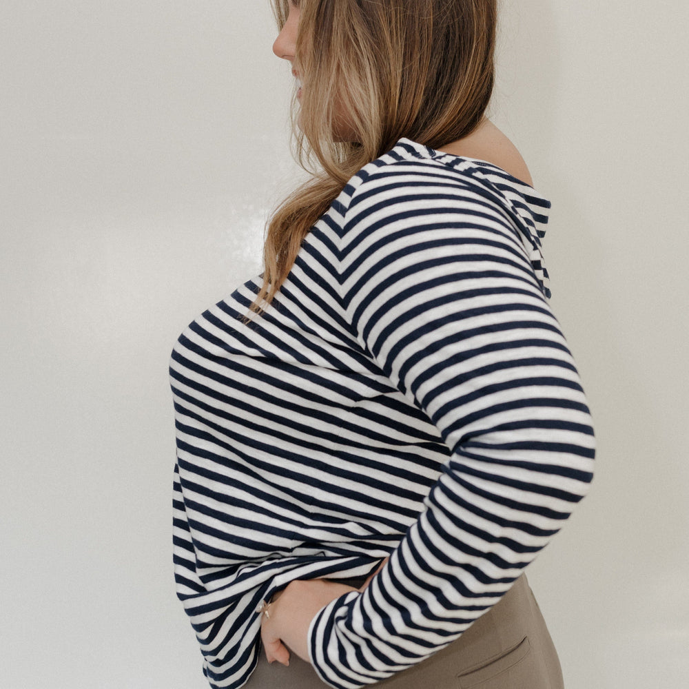 Person wearing a black and white striped hoodie against a plain background