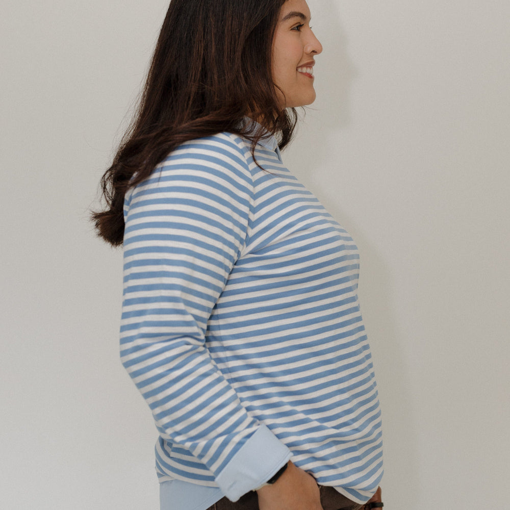Woman wearing a blue and white striped shirt against a plain background