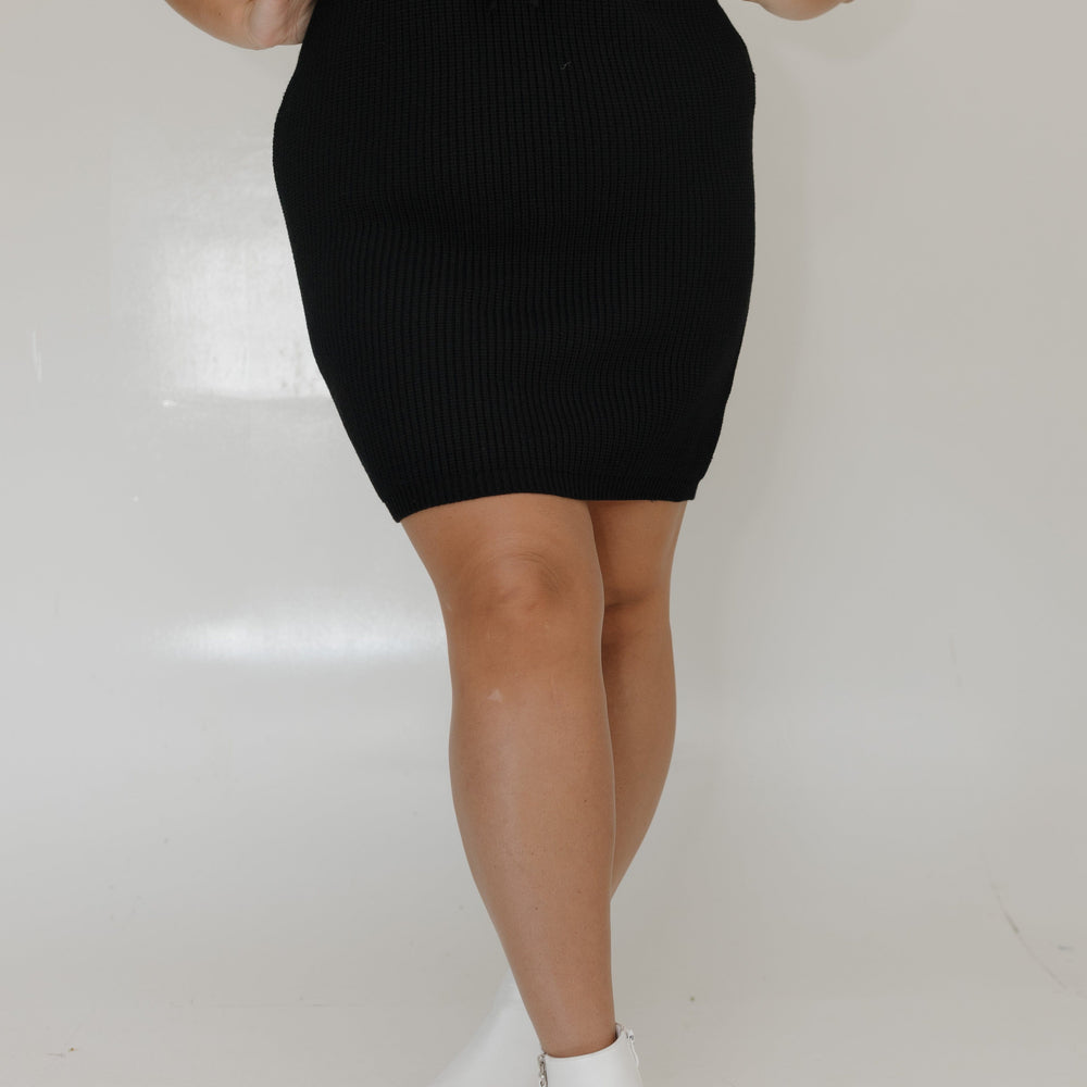 Person wearing a black skirt and green top on a white background