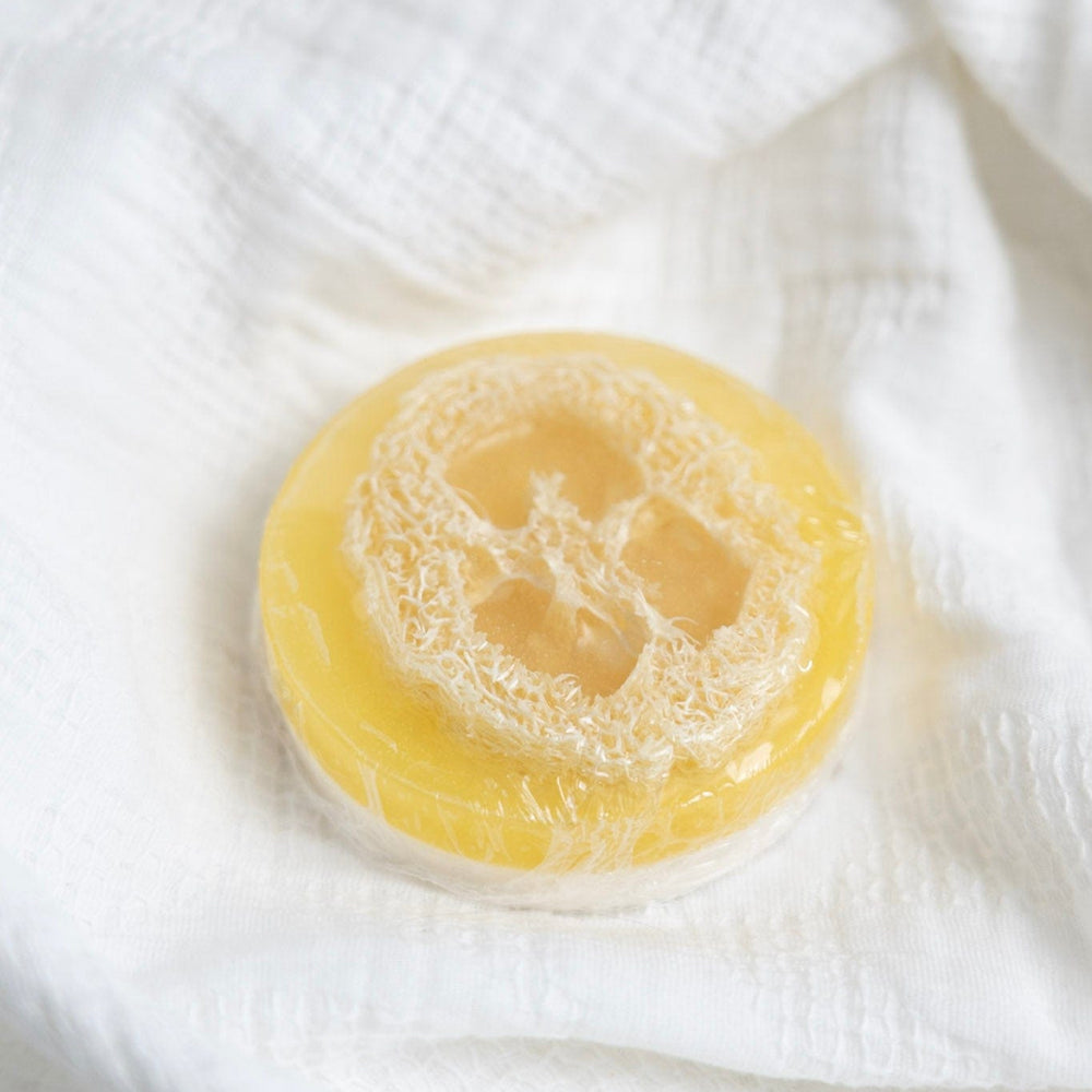Yellow soap bar on a white textured surface
