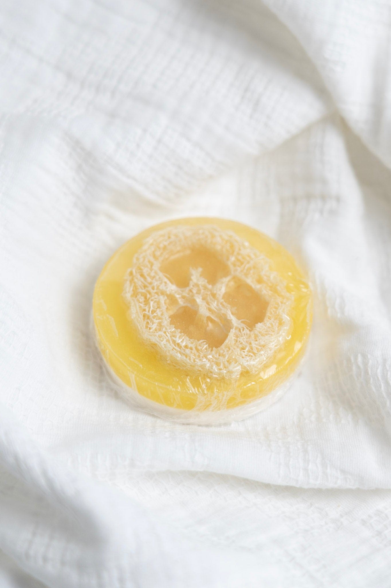 Yellow soap bar on a white textured surface