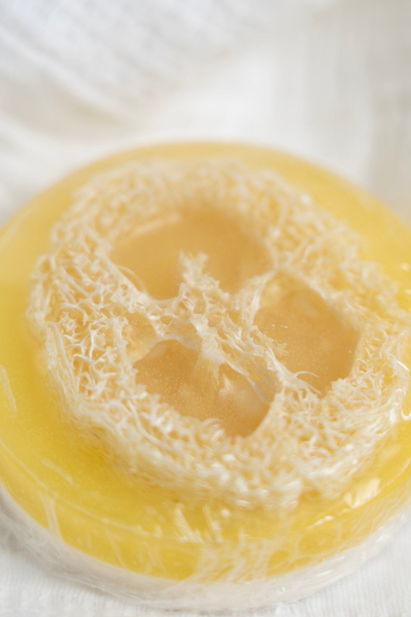 Close-up of a yellow jelly-like dessert with a white lace-like structure on top.