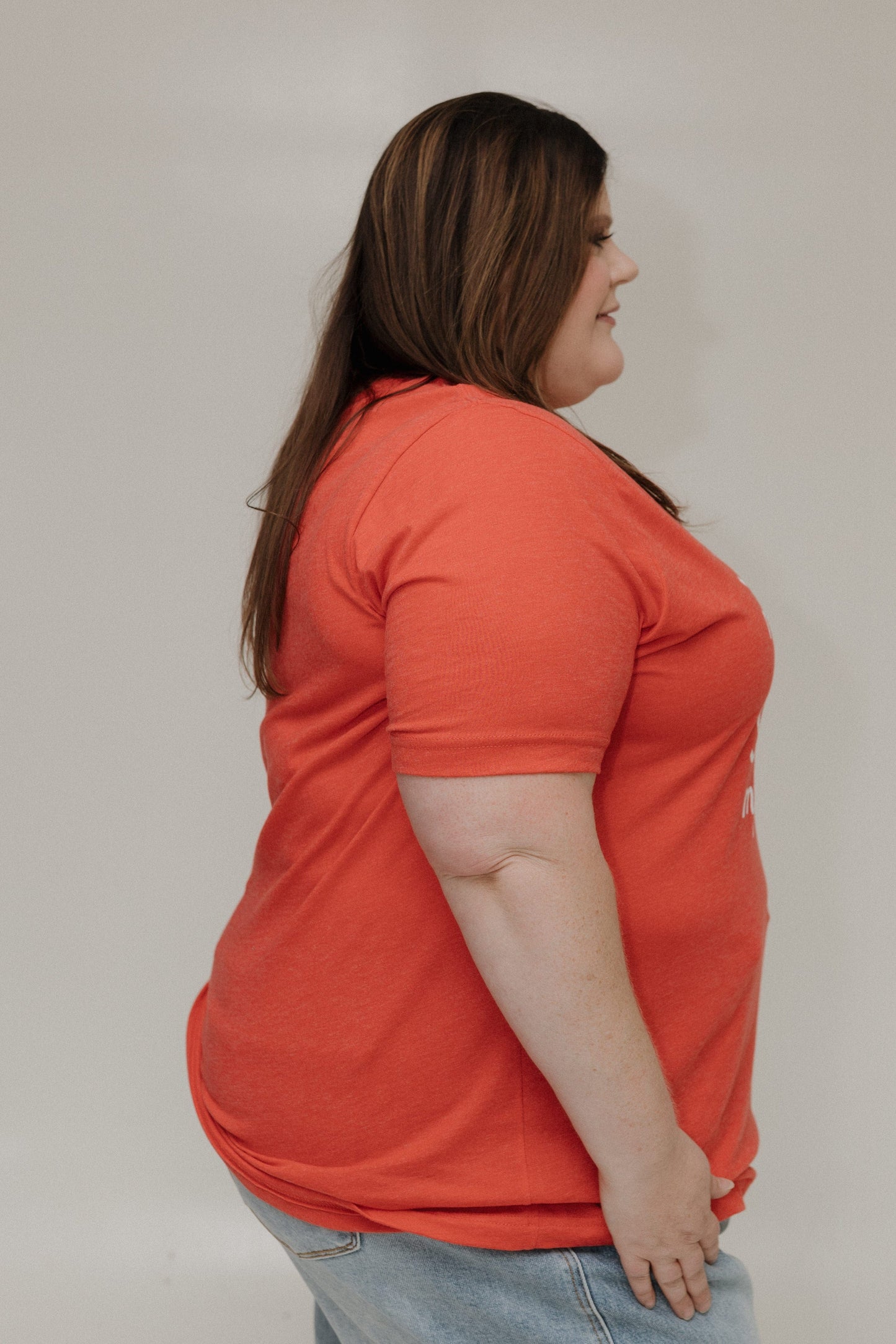 Person wearing an orange shirt against a plain background