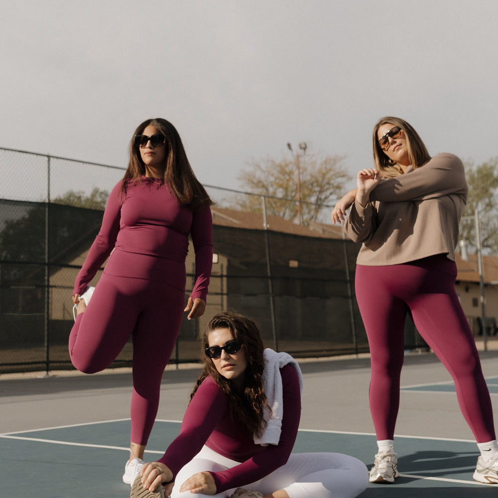 Three women on a tennis court wearing matching outfits. SPANX activewear at Love Marlow in Sioux Falls