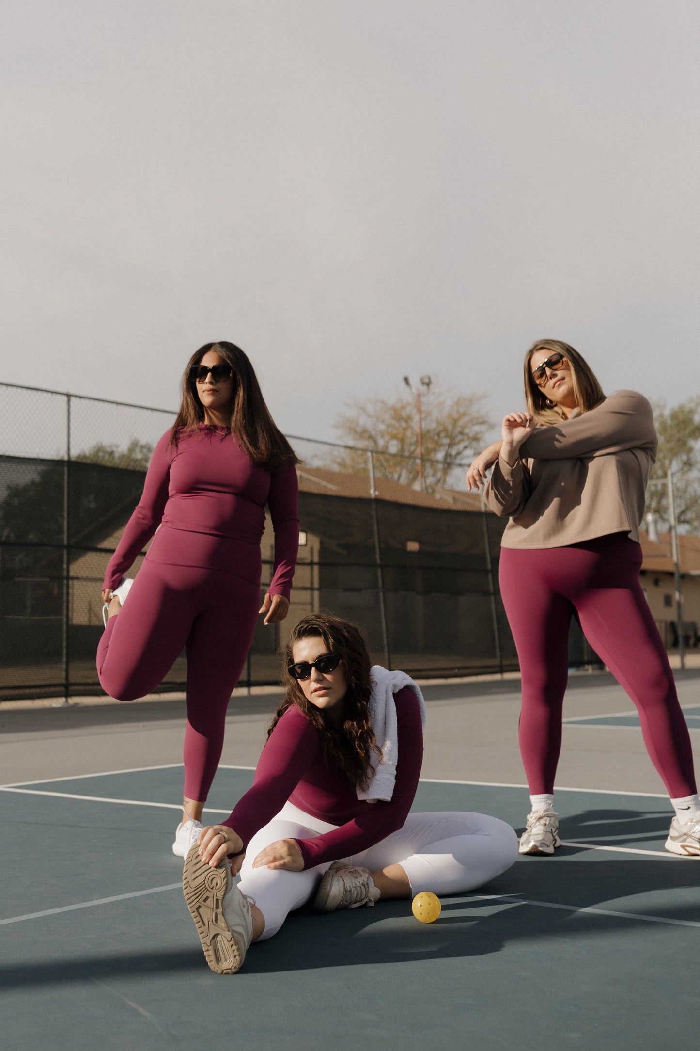 Three women on a tennis court wearing matching outfits. SPANX activewear at Love Marlow in Sioux Falls