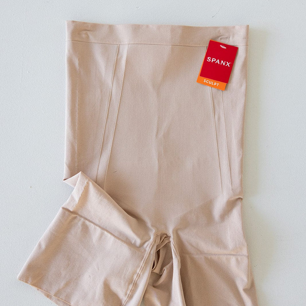 Beige Spanx© ONCORE SHAPER with a red tag attached, displayed on a light surface.