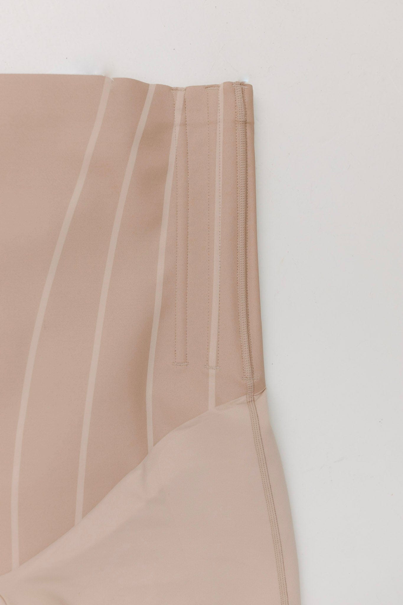 Close-up of a beige fabric with vertical stripes on a white background
