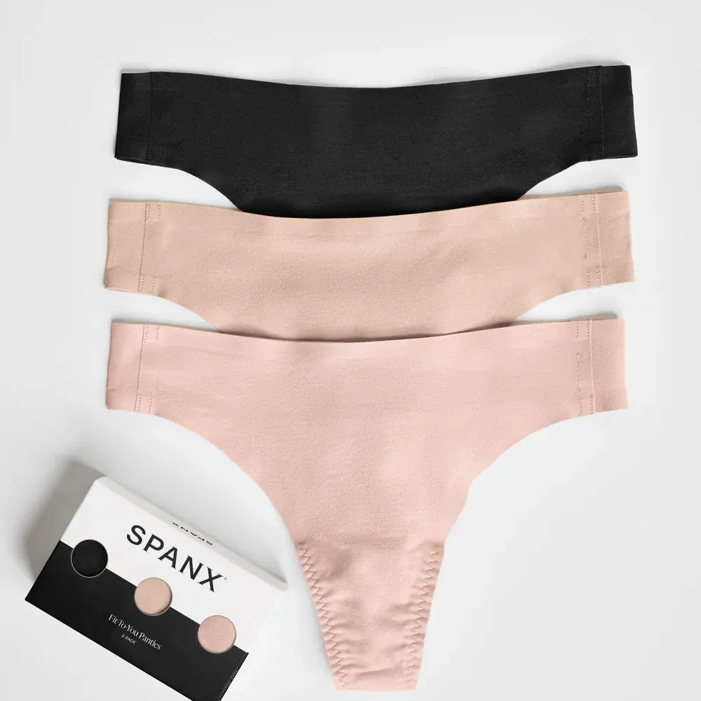 Three pairs of Spanx underwear in black, beige, and pink on a white background with a Spanx packaging box.