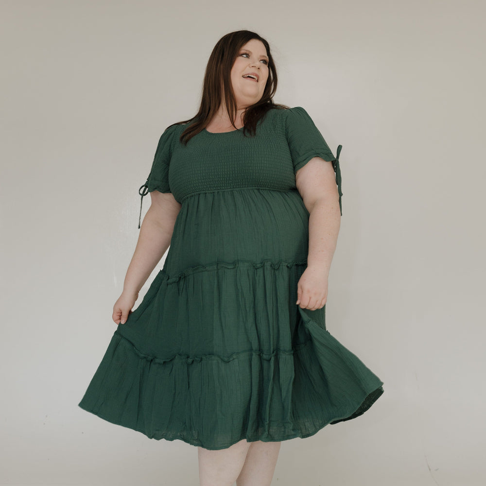 Woman wearing a green dress against a plain background