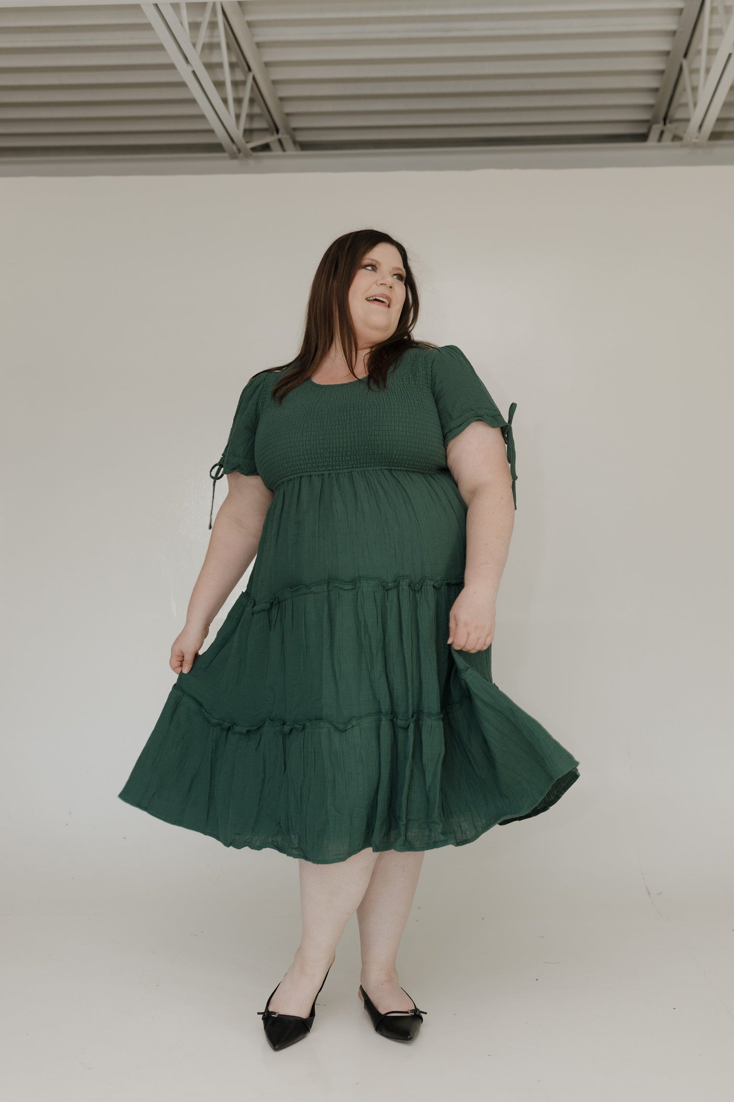 Woman wearing a green dress against a plain background