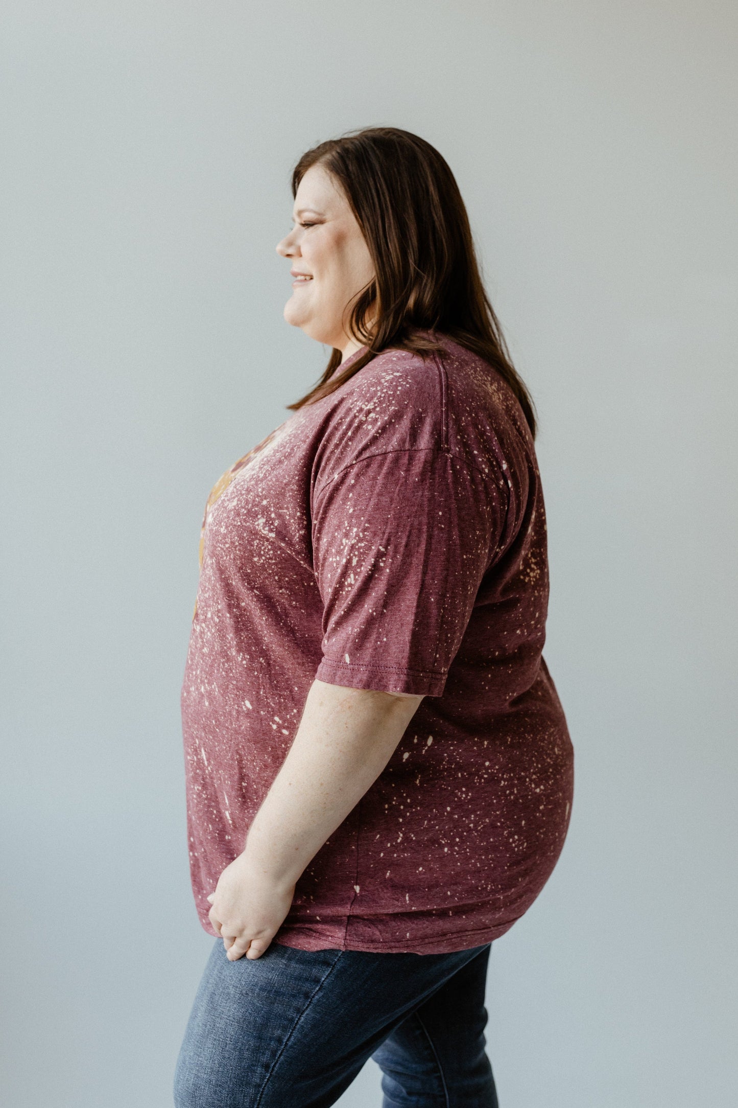 A person in a hand-bleached maroon shirt and jeans stands in profile against a neutral background, reminiscent of the warmth and comfort of grandma’s homemade pumpkin pie.