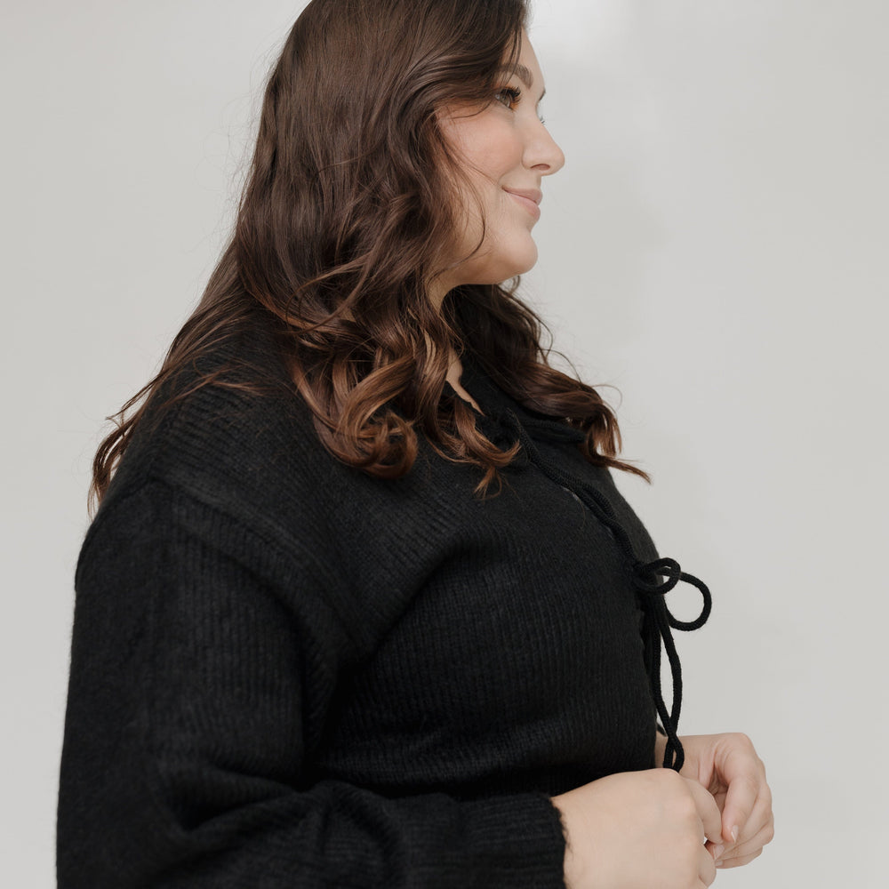 Woman wearing a black coat with a neutral background