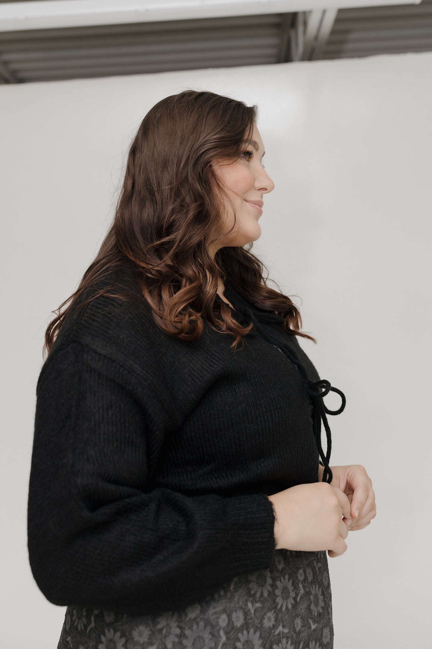 Woman wearing a black coat with a neutral background