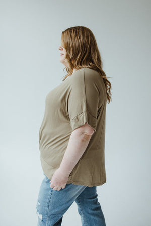 Person with long, light brown hair standing in profile, wearing a Soothing Sage Twist Front Tee by Zenana and light blue jeans.