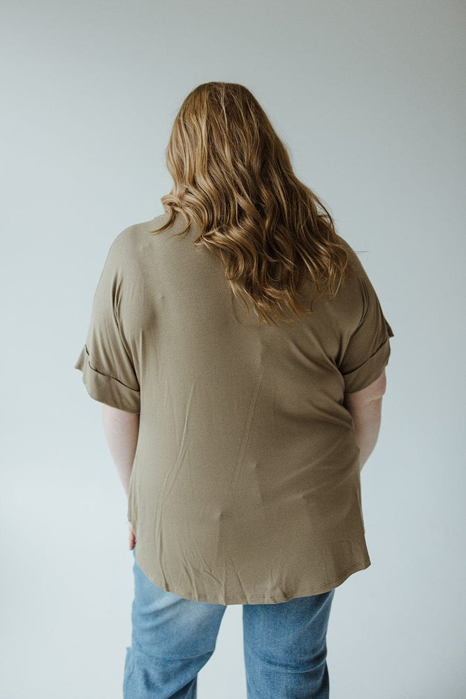 A person with long, wavy hair and wearing the Zenana Twist Front Tee in soothing sage color and jeans is shown from the back against a plain background.