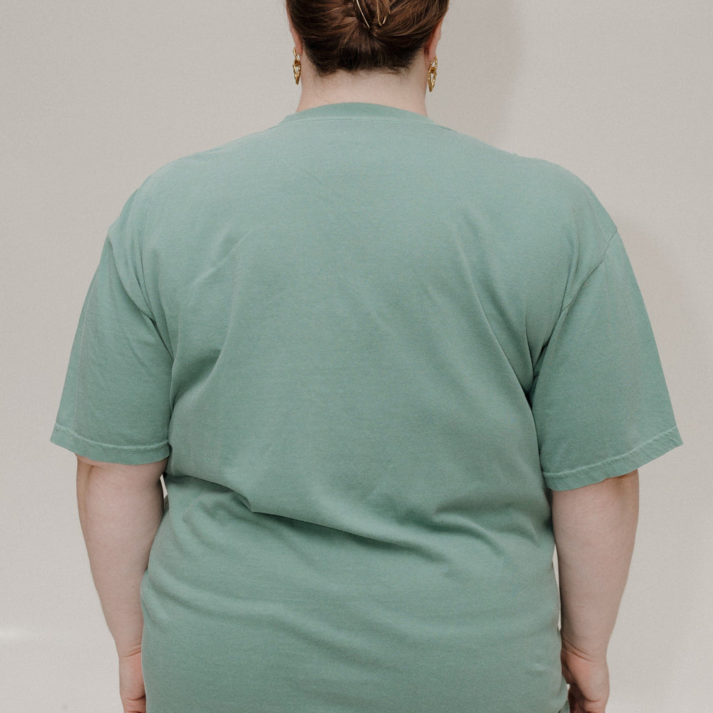Person wearing a green t-shirt against a plain background