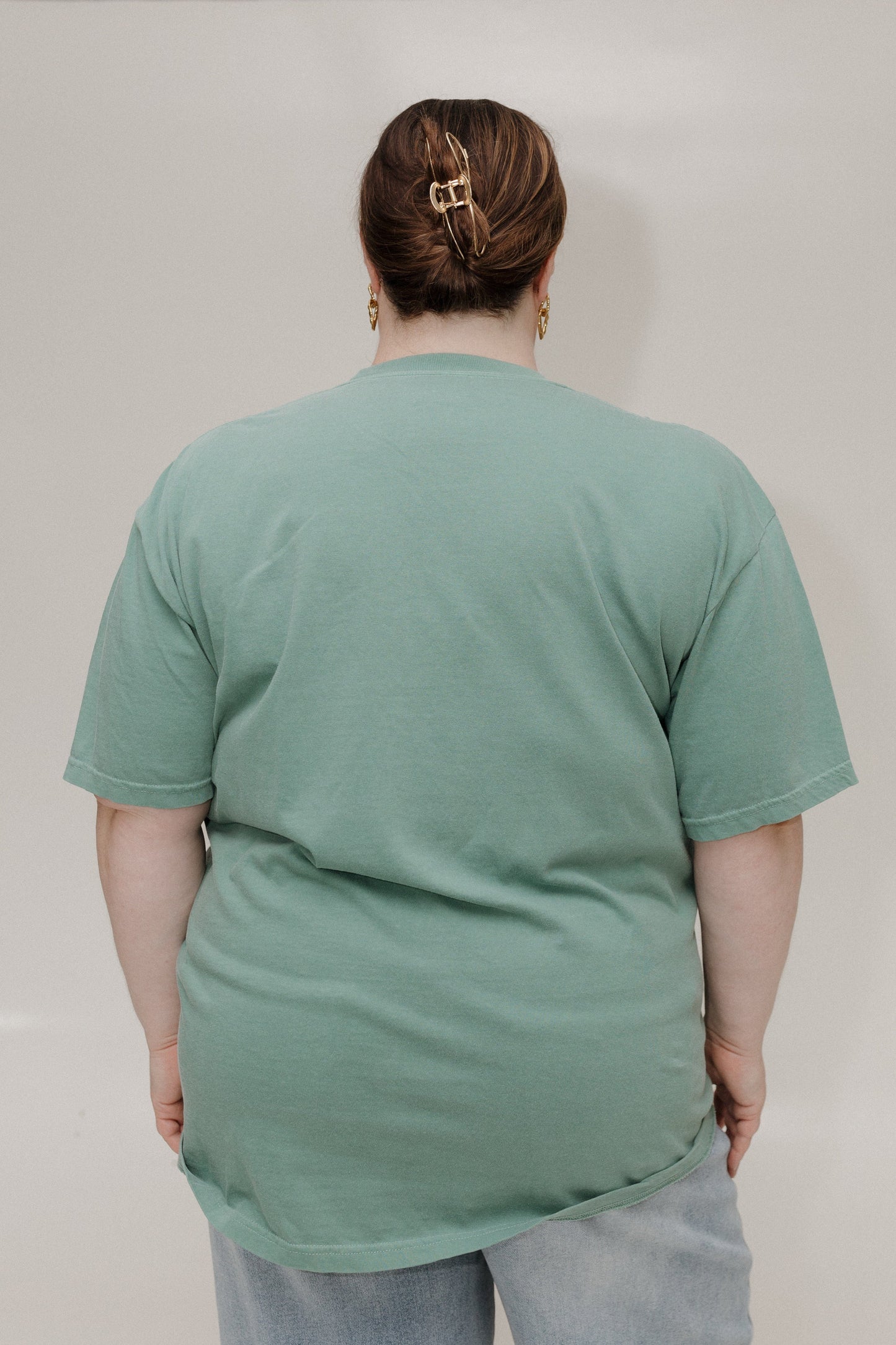 Person wearing a green t-shirt against a plain background