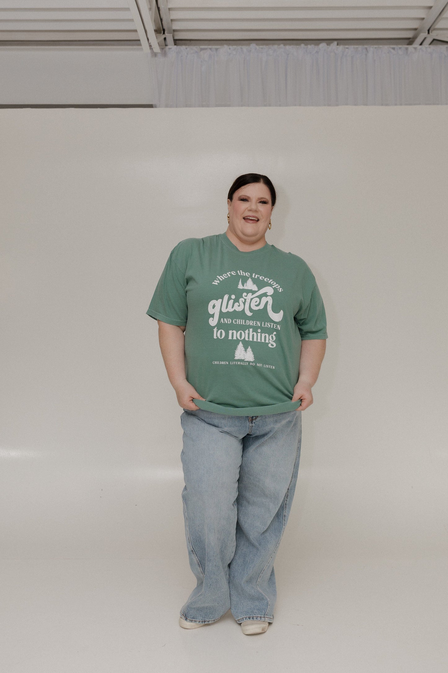 Person wearing a green t-shirt with text on a plain background
