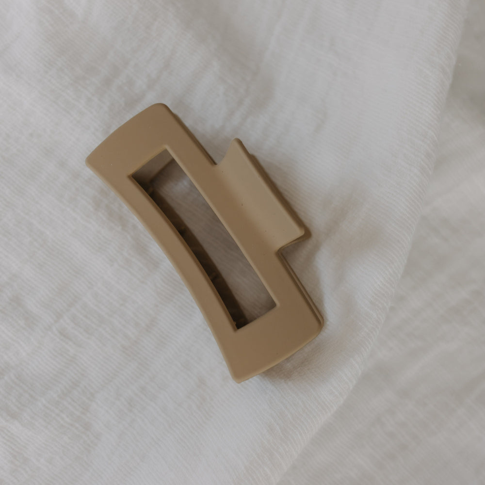 Warm Sand claw clip on a white fabric background