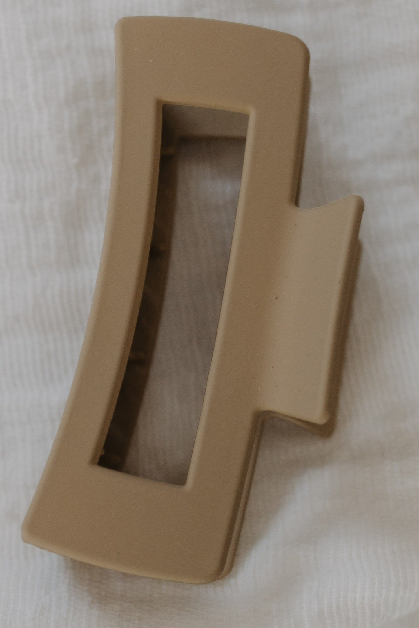 Warm Sand claw clip on a white fabric background