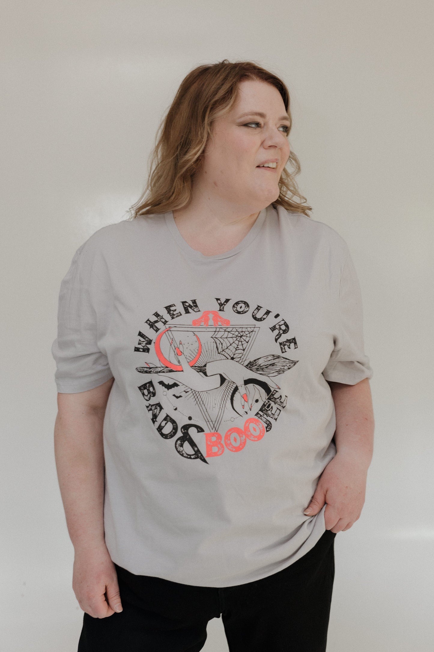 "WHEN YOU'RE BAD AND BOOJEE" GRAPHIC TEE woman wearing a gray t-shirt with graphic design and text on a plain background at Love Marlow