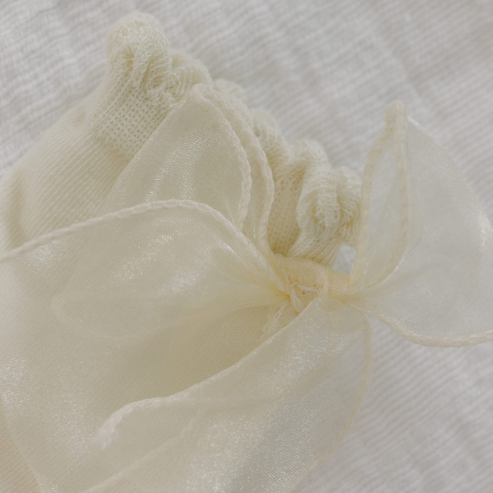 Close-up of a the bow on the socks against a textured white background