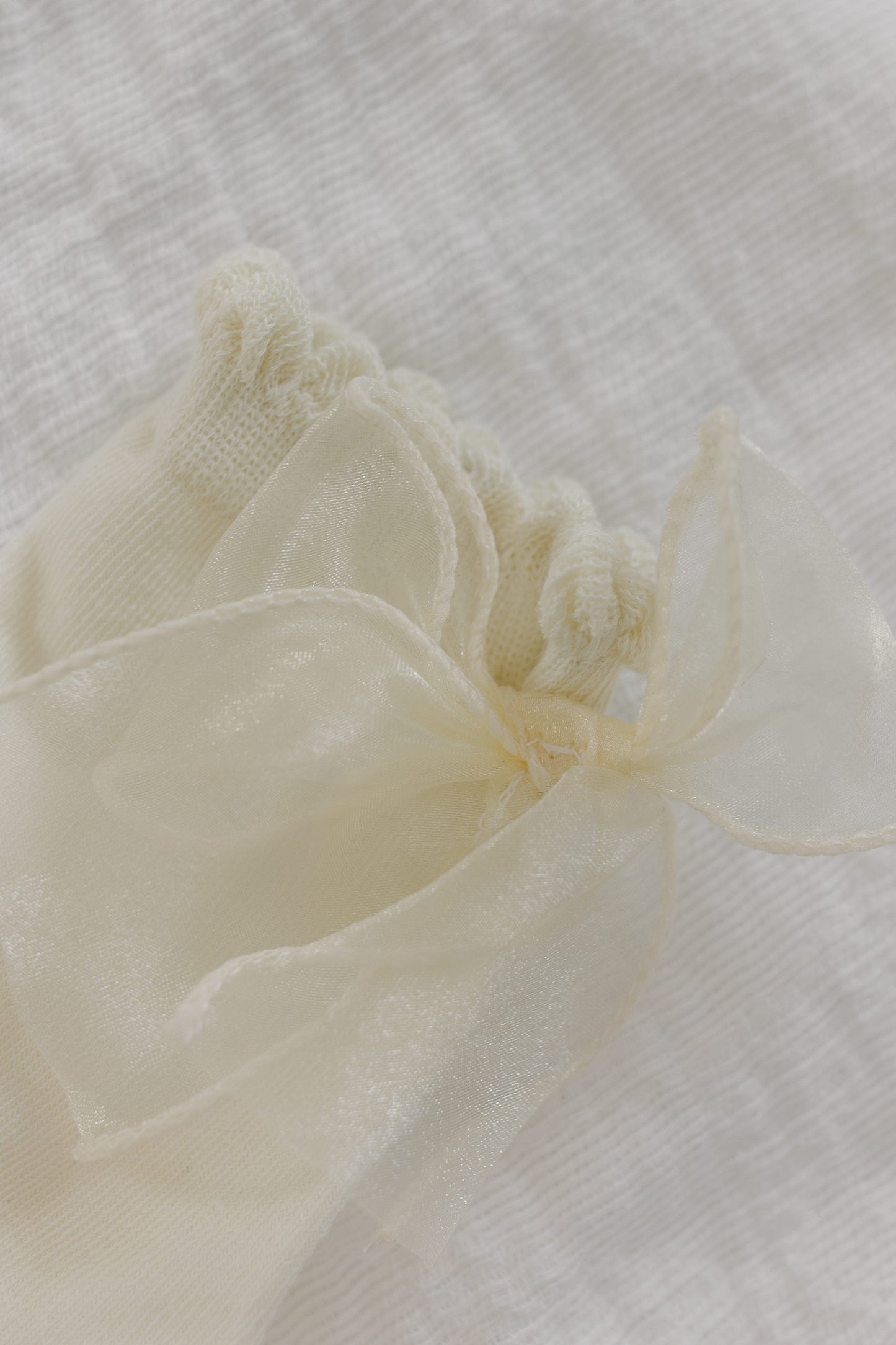 Close-up of a the bow on the socks against a textured white background