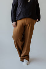 A person wearing the Yesta wide leg tregging with pockets in regular, featuring a pull-on waistband, paired with a black sweater is standing with their back to the camera against a plain background.