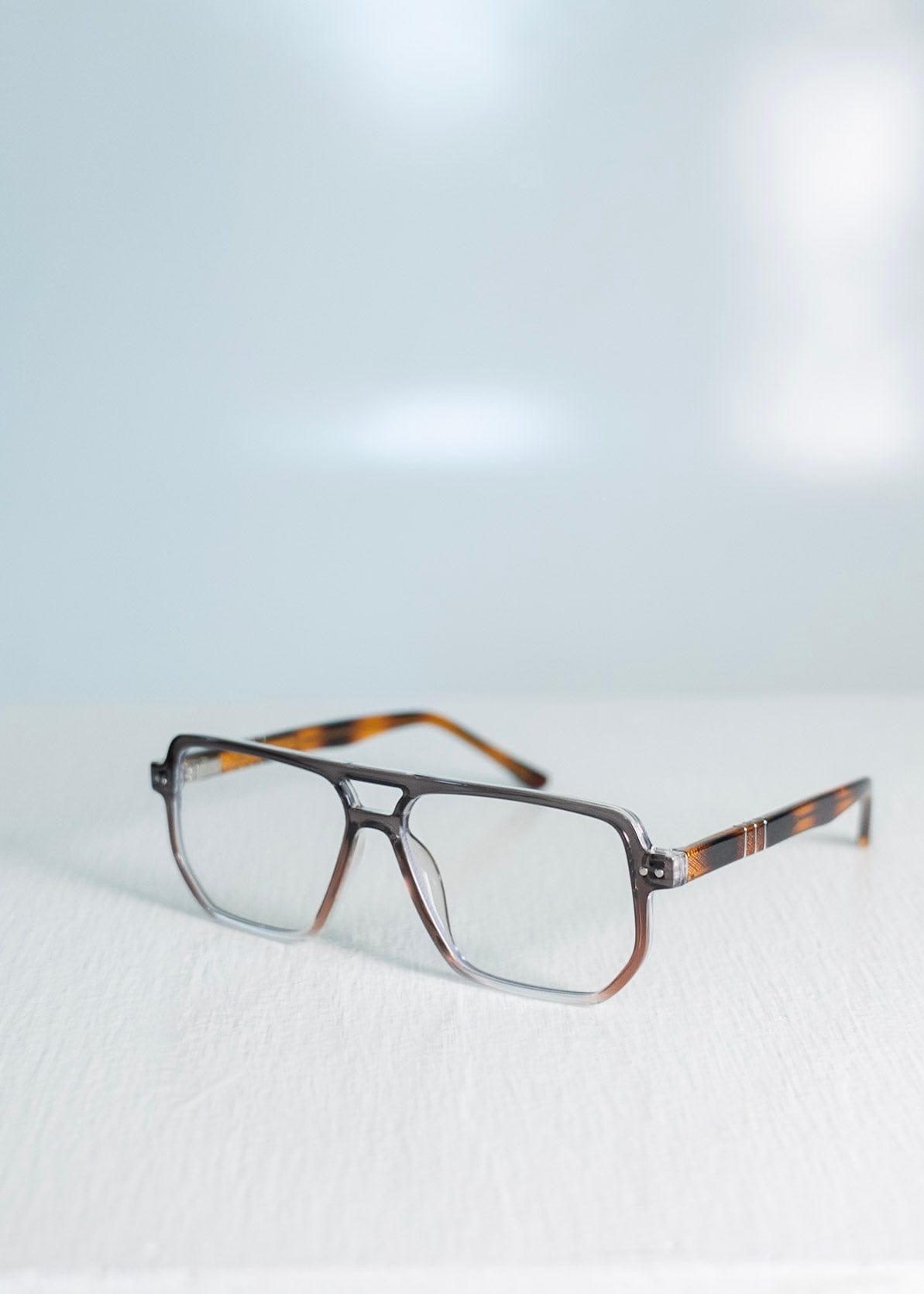 Blue light glasses with a tortoiseshell frame on a light gray background