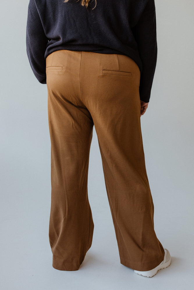 A person wearing the Yesta wide leg tregging with pockets in regular, featuring a pull-on waistband, paired with a black sweater is standing with their back to the camera against a plain background.