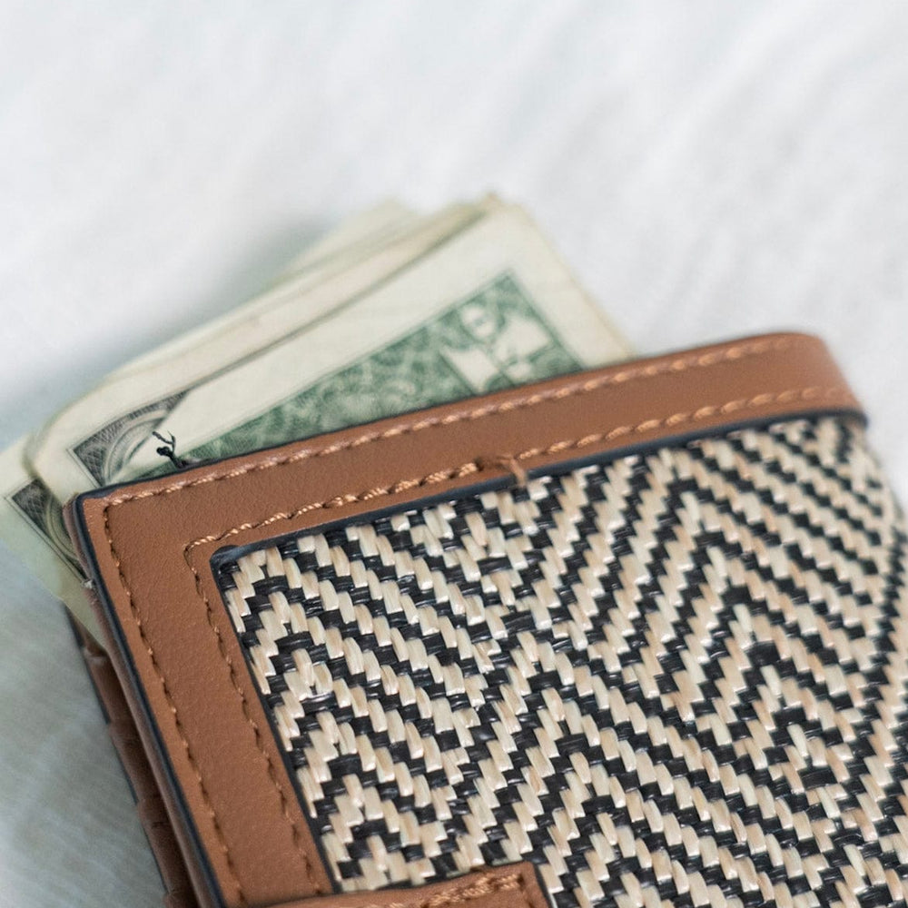 A classic pattern with a color twist makes this unique clutch simply understated. The classic black and natural color is a staple for your purse collection! Plus, so much room for your cards and cash! It has a slip closure and supple faux leather with a fun woven arrow pattern! 