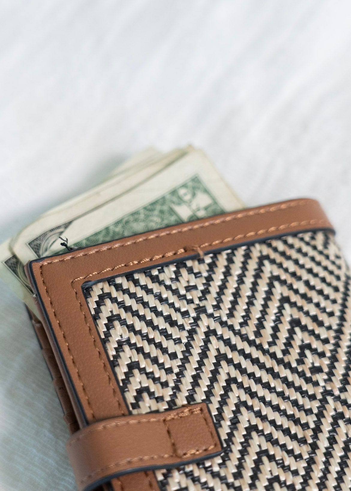 A classic pattern with a color twist makes this unique clutch simply understated. The classic black and natural color is a staple for your purse collection! Plus, so much room for your cards and cash! It has a slip closure and supple faux leather with a fun woven arrow pattern! 