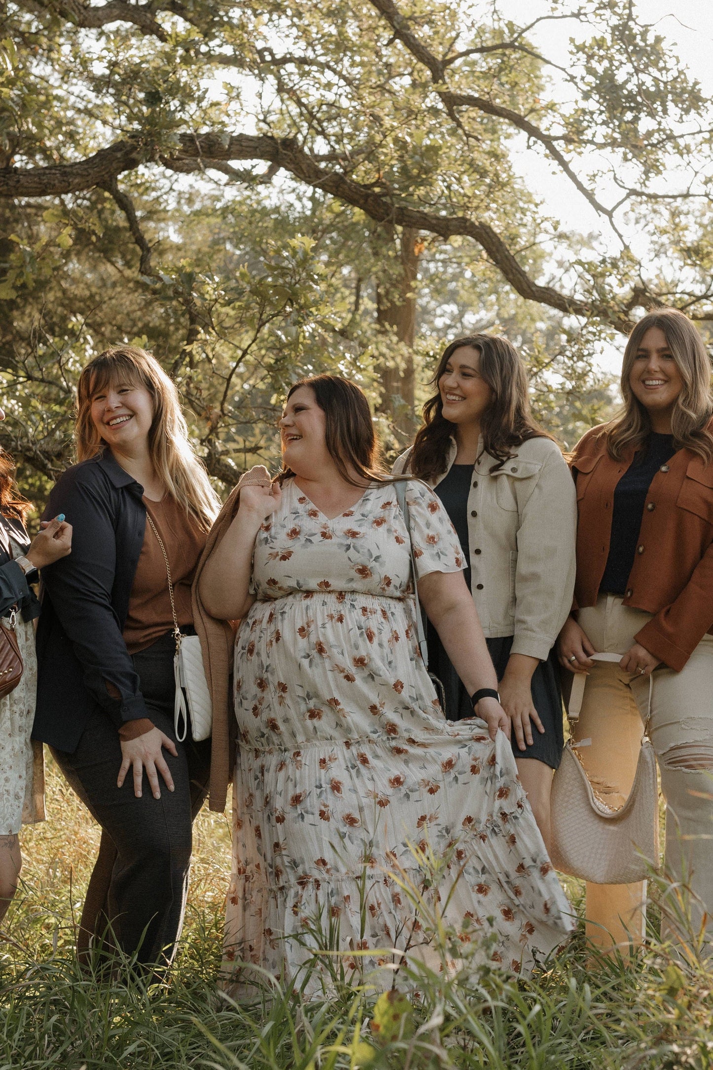 Group of women standing together in a field with trees in the background