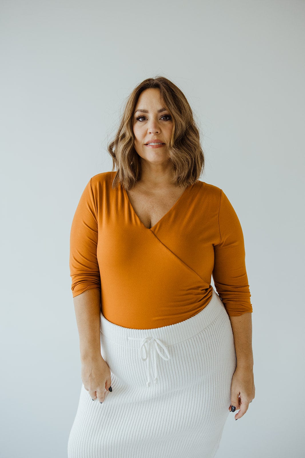 FAUX WRAP BODYSUIT WITH SIDE RUCHING IN AMBER GLOW - Love Marlow